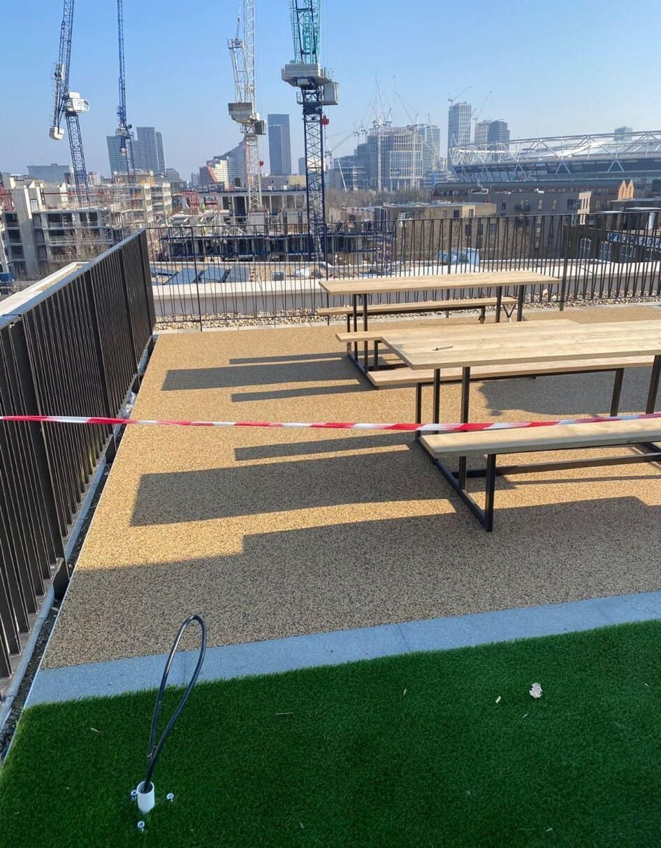 Terasa cu bănci și macarale pe fundal.